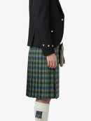 Person wearing a black jacket and green plaid kilt on a white background