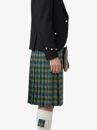 Person wearing a black jacket and green plaid kilt on a white background