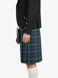 Person wearing a black jacket and green plaid kilt on a white background