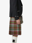 Person wearing a black jacket and plaid kilt on a white background