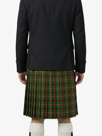 Person wearing a black jacket and green plaid kilt on a white background