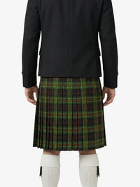 Person wearing a black jacket and green plaid kilt on a white background