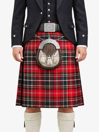 Person wearing a red tartan kilt with a black jacket and white shoes on a white background