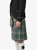 Person wearing a black jacket and plaid kilt on a white background