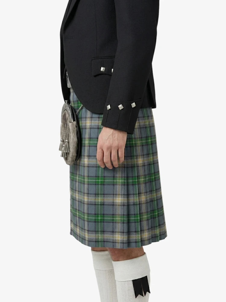 Person wearing a black jacket and plaid kilt on a white background