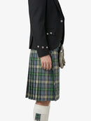 Person wearing a black jacket and plaid kilt on a white background