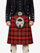 Person wearing a red tartan kilt with a black jacket on a white background