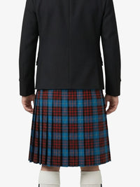 Person wearing a black jacket and a red, blue, and green plaid kilt on a white background