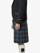 Person wearing a black jacket and a plaid kilt on a white background