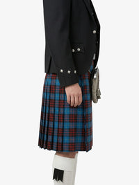 Person wearing a black jacket and blue plaid kilt on a white background