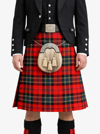 Person wearing a red plaid kilt with a black jacket on a white background