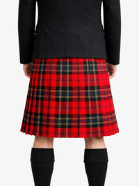Person wearing a red plaid kilt with a black jacket on a white background