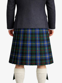 Person wearing a dark gray Jacket and a blue plaid kilt on a white background