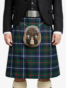 Person wearing a traditional Scottish kilt with a tartan pattern on a white background