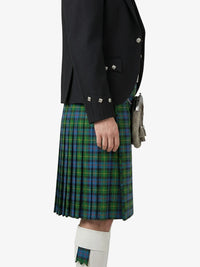 Person wearing a black jacket and green plaid kilt on a white background