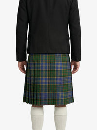 Person wearing a black jacket and green plaid kilt on a white background