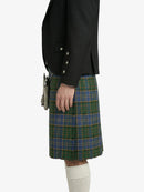 Person wearing a black jacket and green plaid kilt on a white background