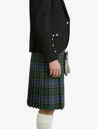 Person wearing a black blazer and green plaid kilt on a white background