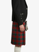 Person wearing a black jacket and red plaid kilt on a white background
