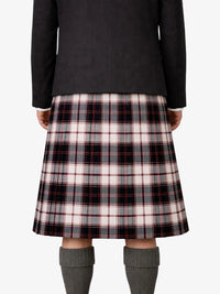Person wearing a black jacket and plaid kilt on a white background