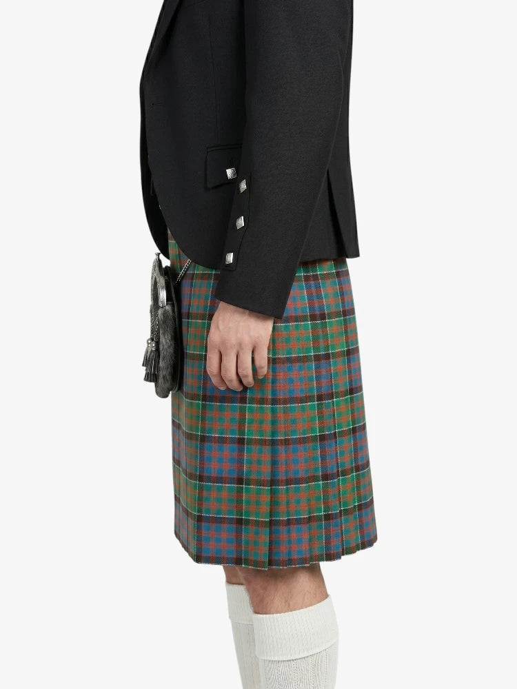 Person wearing a black blazer and plaid kilt on a white background