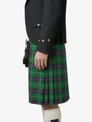 Person wearing a green plaid kilt with a black jacket on a white background