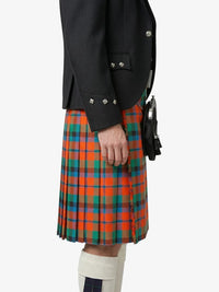 Person wearing a black jacket and a red, green, and blue plaid kilt on a white background