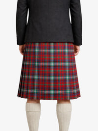 Person wearing a black jacket and red plaid kilt on a white background