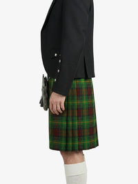 Person wearing a black jacket and green plaid kilt on a white background