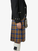 Person wearing a black jacket and blue and yellow plaid kilt on a white background