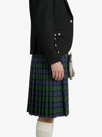 Person wearing a black blazer and green plaid kilt on a white background