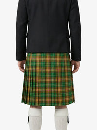 Person wearing a black jacket and green plaid kilt on a white background