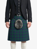 Person wearing a green plaid kilt with a dark jacket on a white background