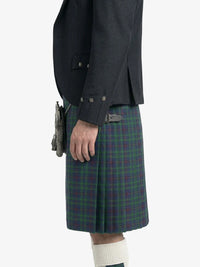 Person wearing a dark jacket and plaid kilt on a white background