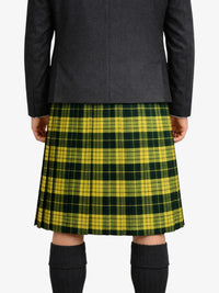Person wearing a green and yellow plaid kilt with a dark coat on a white background