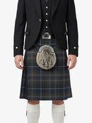 Person wearing a traditional Scottish kilt with a jacket on a white background