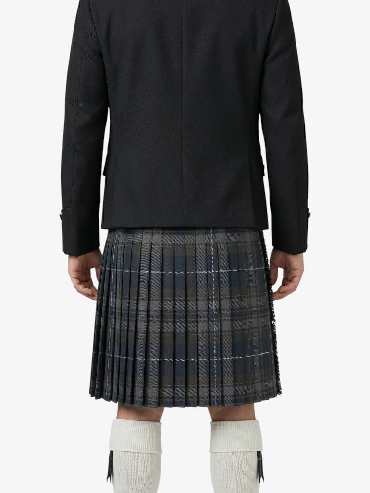 Person wearing a black jacket and plaid kilt on a white background