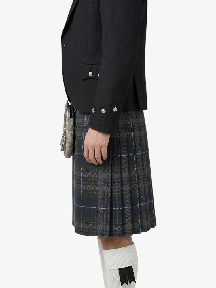 Person wearing a dark jacket and plaid kilt on a white background