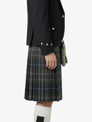 Person wearing a black jacket and plaid kilt on a white background