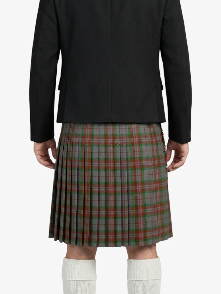 Person wearing a black jacket and plaid kilt on a white background