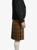 Person wearing a black blazer and plaid kilt on a white background