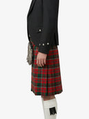Person wearing a black jacket and red plaid kilt on a white background