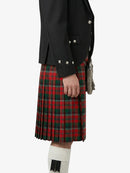 Person wearing a black jacket and red plaid kilt on a white background