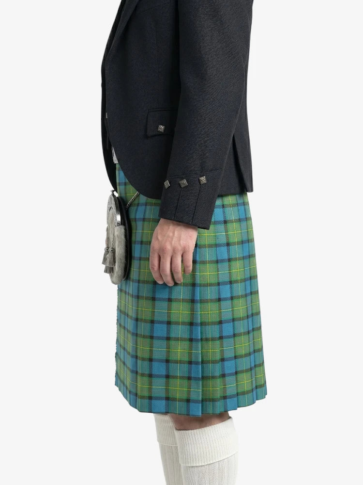 Person wearing a black jacket and green plaid kilt on a white background