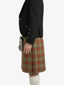 Person wearing a black jacket and plaid kilt on a white background