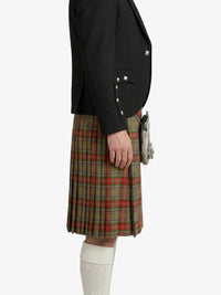 Person wearing a black blazer and plaid kilt on a white background