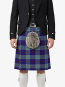 Person wearing a traditional Scottish kilt with a tartan pattern on a white background