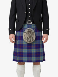 Person wearing a traditional Scottish kilt with a tartan pattern on a white background