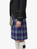 Person wearing a black jacket and blue plaid kilt on a white background