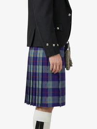 Person wearing a black jacket and a plaid kilt on a white background